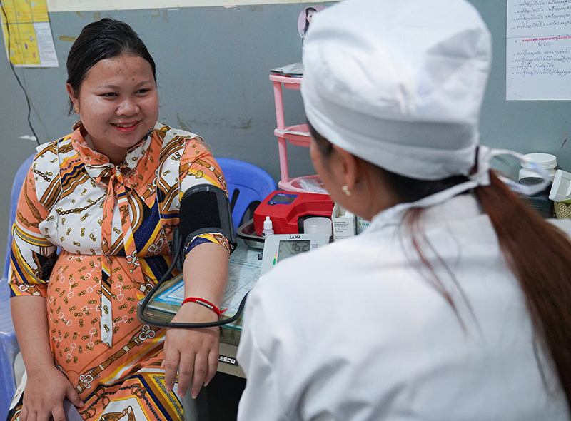 A healthcare worker performing a check up on a woman.