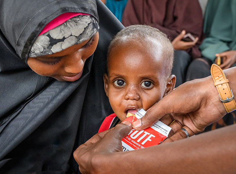 A malnourished child being fed therapeutic food.