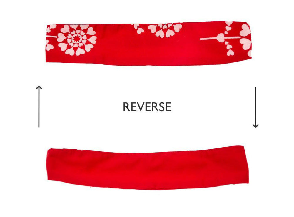 Two sides of the red Ivy & Alex headband showing one side with the floral design and the opposite side with plain colour.